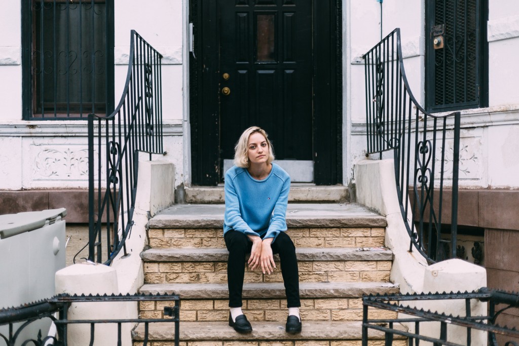 Alice Lancaster sitting on a stoop for Art Report interview