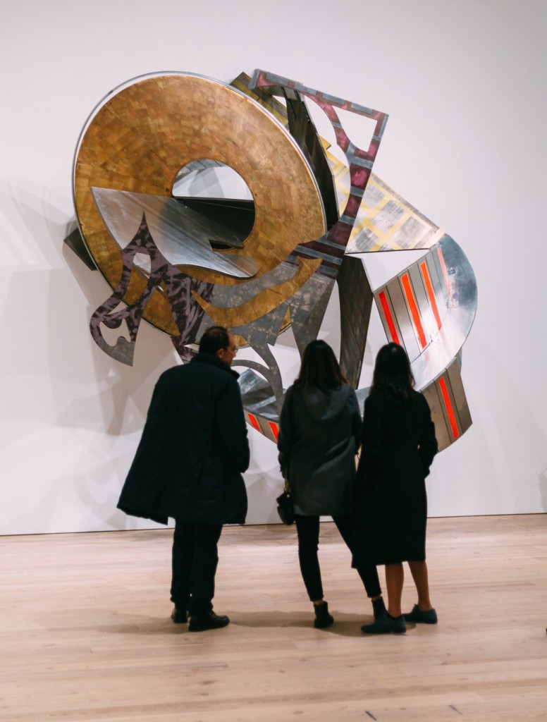 Museum goers at Frank Stella Retrospective looking at a sculpture