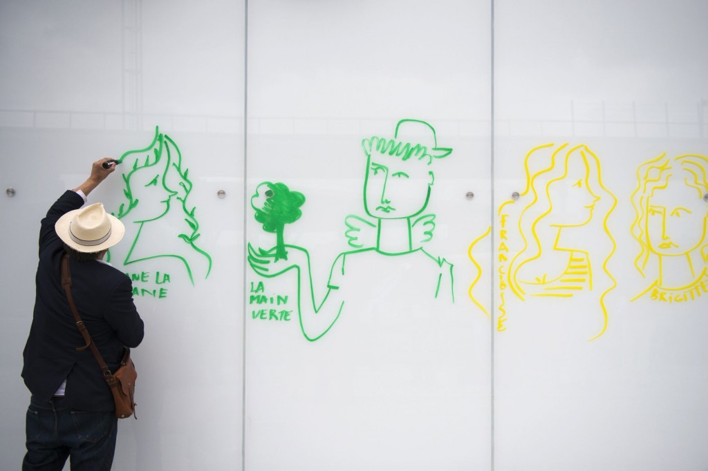 French fashion designer and artist Jean-Charles de Castelbajac draws a design on the walls of Paris-Orly aiport on July 28, 2015 in Orly. AFP PHOTO / MARTIN BUREAU